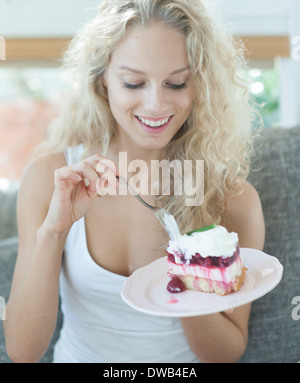 Schöne Frau mit Himbeer Kuchen im Haus Stockfoto