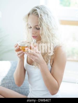 Junge Frau mit Augen geschlossen genießen-Kräuter-Tee im Haus Stockfoto