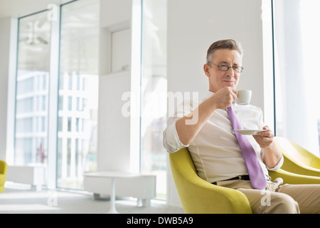 Reife Geschäftsmann Kaffeetrinken im Büro lobby Stockfoto