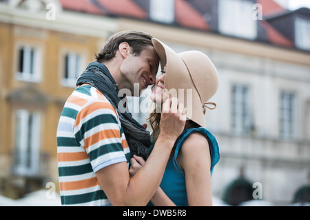 Romantischer junger Mann küsst Frau gegen Gebäude Stockfoto