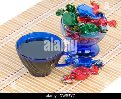 Tasse schwarzer Tee und Schokolade in eine Schüssel mit blauem Glas Stockfoto