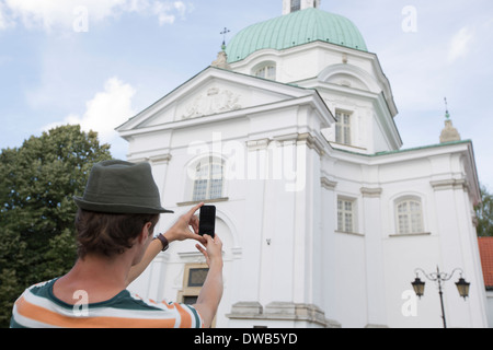 Heckansicht des jungen Mann Fotografieren St. Kasimir Kirche, Warschau, Polen Stockfoto