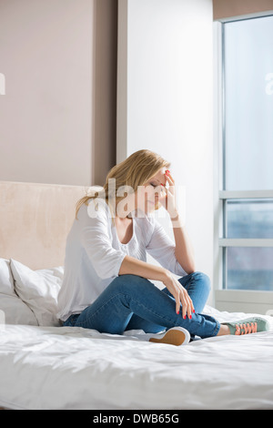 Voller Länge gestresste Frau mit Hand auf Facesitting auf Bett Stockfoto