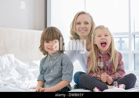 Porträt der glückliche Mutter mit Kindern im Schlafzimmer Stockfoto