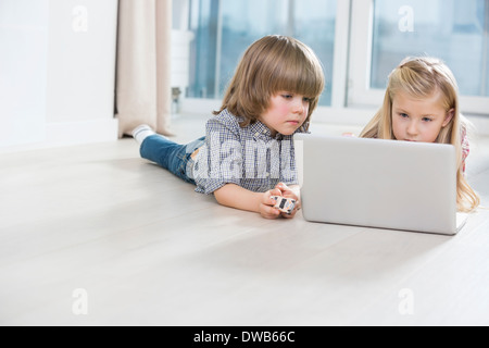 Bruder und Schwester mit Laptop im Stock zu Hause Stockfoto