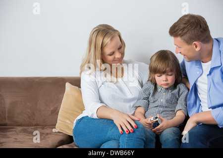 Eltern sitzen mit verärgert Sohn zu Hause auf sofa Stockfoto