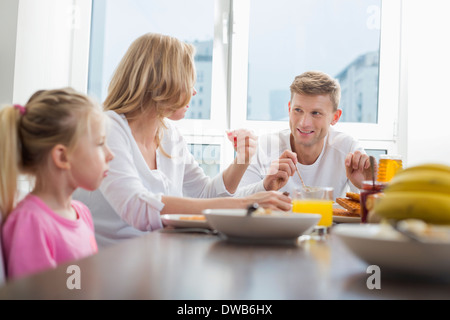 Glückliche Familie von drei frühstücken am Tisch Stockfoto