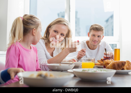 Glückliche Familie mit Kindern frühstücken am Tisch Stockfoto
