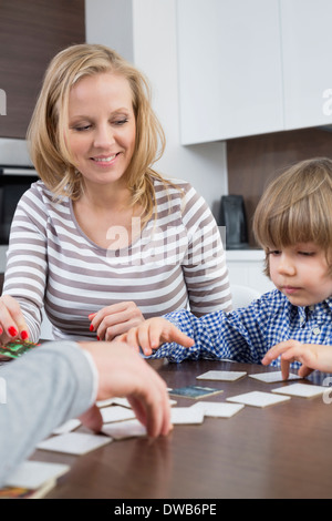 Junge Spielkarten mit den Eltern zu Hause Stockfoto