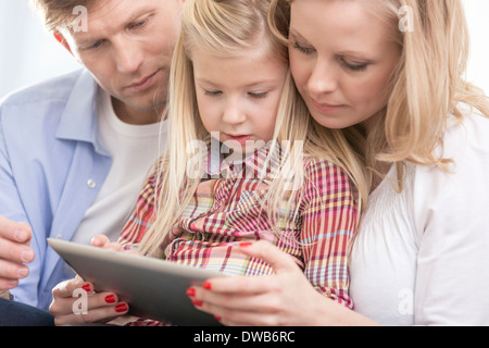 Mitte Erwachsenen Eltern mit tablet-PC mit Tochter zu Hause Stockfoto