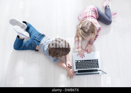 Erhöhte Ansicht von Bruder und Schwester mit Laptop im Stock zu Hause Stockfoto