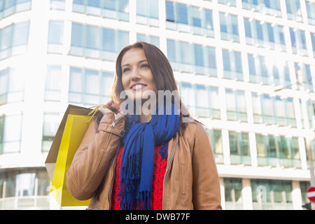 Nachdenkliche junge Frau Einkaufstaschen im winter Stockfoto