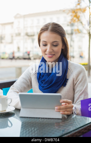 Junge Frau mit Tablet-PC am Straßencafé Stockfoto