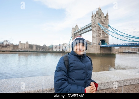 Porträt von Mitte erwachsenen Mannes in warme Kleidung stehen vor der Tower Bridge, London, UK Stockfoto
