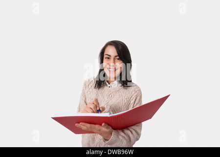 Porträt von glücklich Geschäftsfrau mit Buch und Stift auf weißem Hintergrund Stockfoto