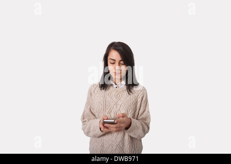 Geschäftsfrau Textnachrichten durch Smartphone vor grauem Hintergrund Stockfoto