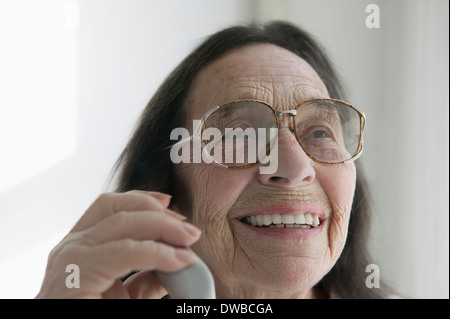 Ältere Frau mit Brille auf dem Handy Stockfoto