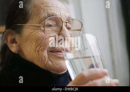 Ältere Frau mit Glas Trinkwasser Stockfoto