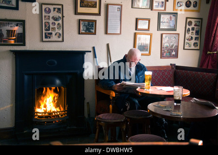 Mann liest eine Zeitung im Ecke House Bar in Ardara County Donegal, Irland Stockfoto