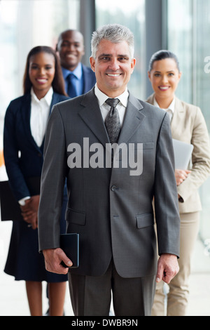 fröhlichen senior Business Leader Stand vor seinem Team im Büro Stockfoto