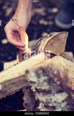 Mannes Hand zündenden Lagerfeuer Stockfoto