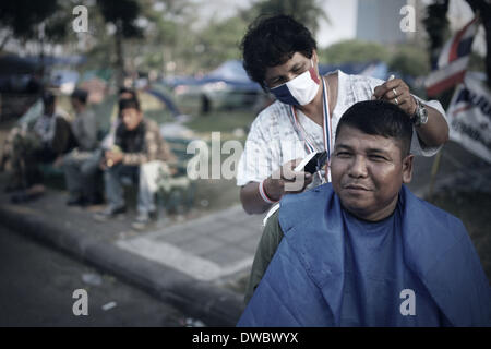 Bangkok, Thailand. 5. März 2014. Ein Anti-Regierungs-Demonstranten bekommen einen Haarschnitt im Lumpini Park, Bangkok, Thailand. Lumpini Park ist der Sitz der Anti-Regierungs-Demonstranten nach Protest Führer Suthep.T das Ende der Bangkok Abschaltung am 3. März angekündigt. Rohan Radheya/ZUMAPRESS.com/Alamy © Live-Nachrichten Stockfoto