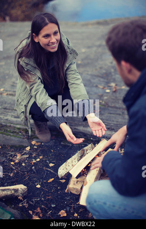 Frau Mann betrachten, während Sie am Lagerfeuer sitzen Stockfoto