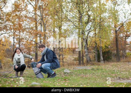 Voller Länge des Paares pitching Zelt im Wald Stockfoto