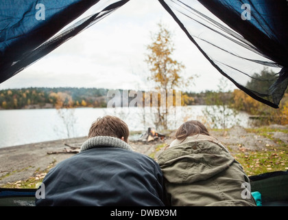 Rückansicht des Paares im Zelt am Ufer liegend Stockfoto