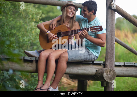 Teenager-paar Gitarre spielen und singen Stockfoto