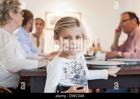 Porträt eines Mädchens mit Familie am Esstisch sitzen Stockfoto