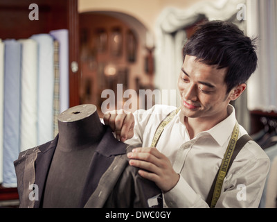 Lehrling Schneider pinning Kleidungsstück im traditionellen Schneider shop Stockfoto