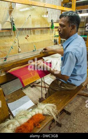 Indien Tamil Nadu Kanchipuram factory workshop Mann Mann im blauen Hemd Holz- Webstuhl roter Seide tuch Thema damen Sari Sari gold Kleidung Stockfoto