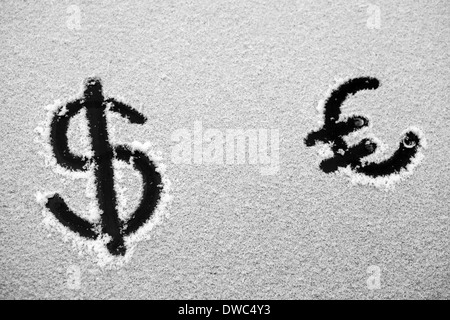 Bild von einem Dollar und Euro Zeichen gezeichnet im Schnee Stockfoto