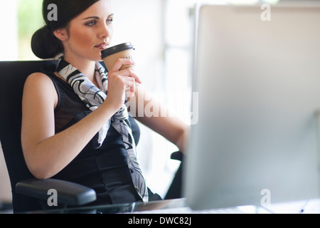 Junge Unternehmerin eine Kaffee-Pause am Schreibtisch Stockfoto