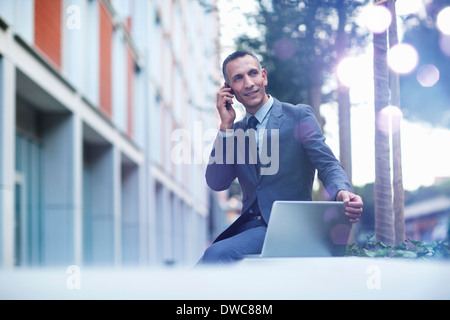 Geschäftsmann am Smartphone sprechen und mit Blick auf leuchtende Lichter Stockfoto