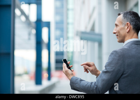 Geschäftsmann mit Touchscreen auf smartphone Stockfoto