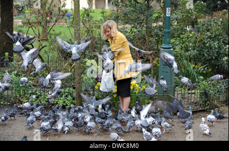 Frau, Fütterung der Tauben in Brighton Pavilion Gardens Stockfoto