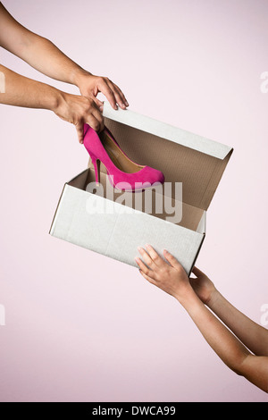 Studio gedreht Übergabe Schuhkarton mit rosa hochhackige Schuhe Stockfoto