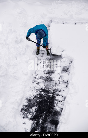 Erwachsenen Schneeschaufeln nach Wintersturm. Stockfoto