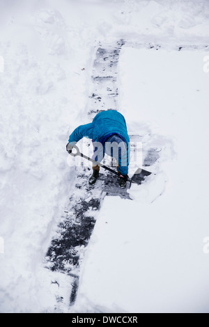 Erwachsenen Schneeschaufeln nach Wintersturm. Stockfoto