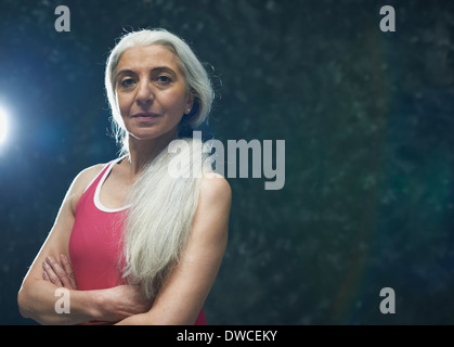 Reife Frau mit langen grauen Haaren mit rosa Weste Stockfoto