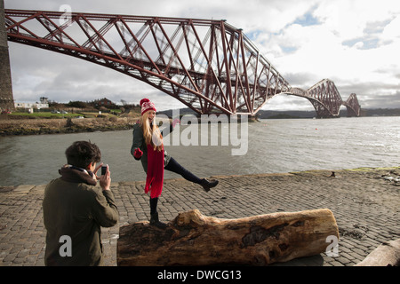 Ein junges Paar posieren vor die Forth Rail Bridge in Queensferry, in der Nähe von Edinburgh, Schottland Stockfoto