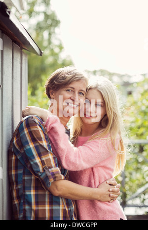 Porträt von Mutter und Tochter umarmt am Hof Stockfoto