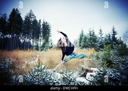 Mitte Erwachsene Frau praktizieren Yoga im Wald Stockfoto