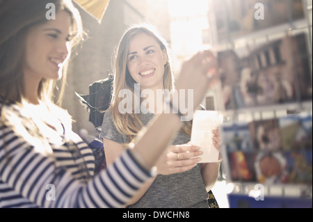 Zwei junge Freundinnen Blick auf Postkarten, Valencia, Spanien Stockfoto