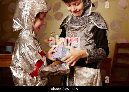 Zwei jungen, verkleidet als Ritter, einem empfangenden Geburtstagsgeschenk Stockfoto