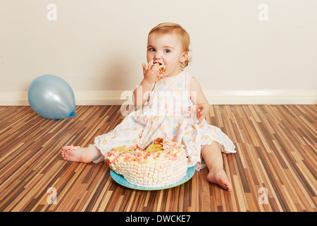 Kleinkind Mädchen verschlingt Geburtstagstorte Stockfoto