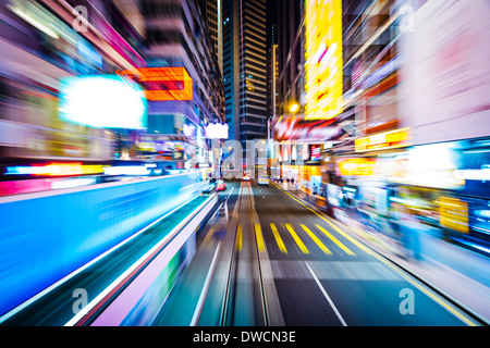 Hong Kong, China-Bewegungsunschärfe durch die Stadt von einer Straßenbahn. Stockfoto