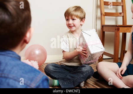 Kinder auf Party, junge hält Geburtstagsgeschenk Stockfoto